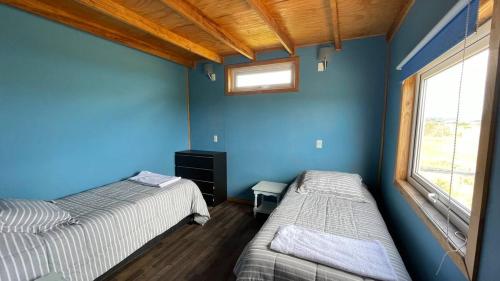 安库德Casa en la Playa的配有两张床铺的蓝色墙壁和窗户