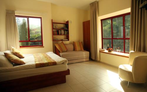 Gid‘ona吉尔博亚旅馆 - 本哈里姆的一间卧室配有一张床、一张沙发和窗户。
