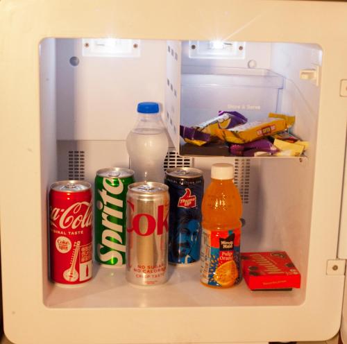 班加罗尔Golden Fortune Hotel的配有汽水和饮料的开放式冰箱
