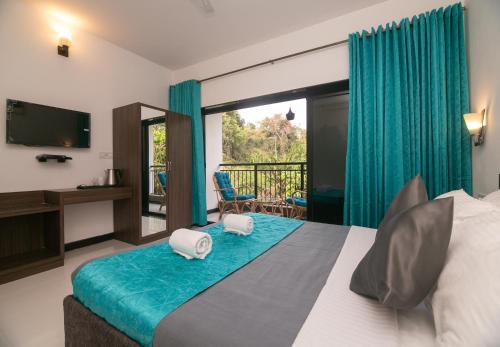 巴加Aloha Holiday Resort的一间卧室设有一张带电视的床和一个阳台。