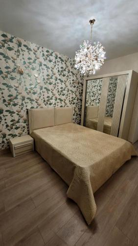 第比利斯Sweet Memories的一间卧室配有一张大床和一个吊灯。
