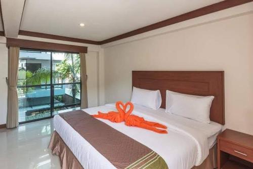 卡塔海滩Kata Noi Bay Inn的卧室床上的橙色 ⁇ 带