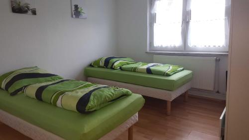 埃森holiday apartment essen 3的带窗户的客房内的两张绿色床