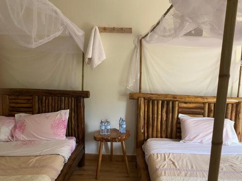 KinkiziRafiki Safari Lodge Bwindi的一间卧室设有两张双层床和一张桌子