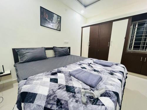 海得拉巴Bigson Service Apartments Gachibowli的一间卧室配有一张床铺,床上有毯子