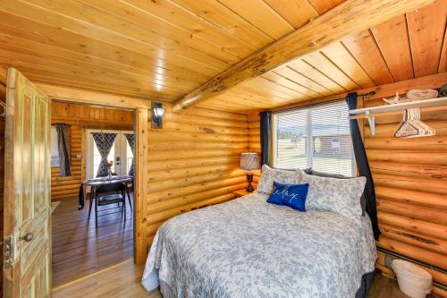 Trout CreekCozy Farm Cabin - 9 Mi to Trout Creek!的小木屋内一间卧室,配有一张床