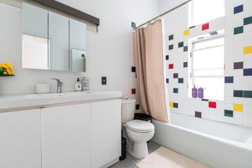 纽约4BR in the heart of Tribeca的浴室配有盥洗盆、卫生间和浴缸。
