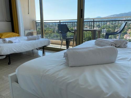曼德琉-拉纳普勒Studio Cannes Marina Mandelieu的带阳台的酒店客房内的两张床