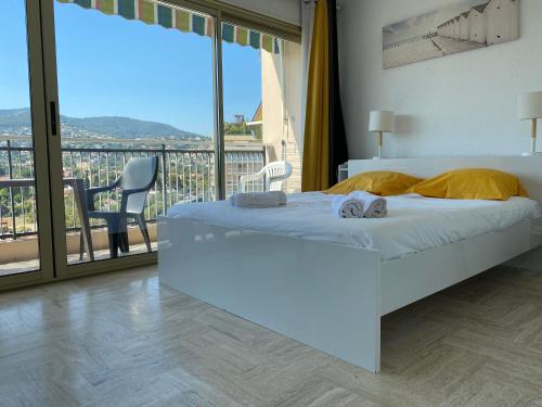 曼德琉-拉纳普勒Studio Cannes Marina Mandelieu的一间带白色床的卧室和一个阳台