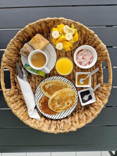 圣安尼Villa Théo , chambre d'hôtes , petit déjeuner的包括煎饼和水果的早餐篮