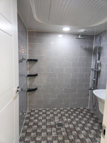浦项Urbanspace Pohang的带淋浴的浴室,铺有瓷砖地板。