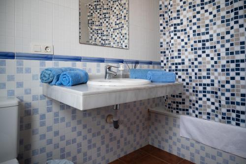 卡亚俄萨尔瓦赫VILLA ADELA的浴室设有水槽和蓝色毛巾