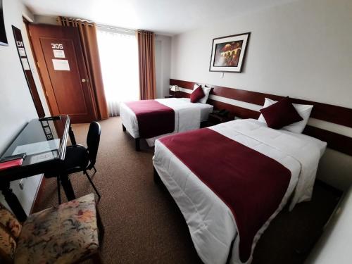 阿雷基帕Bella AQP的酒店客房配有两张床和一张书桌