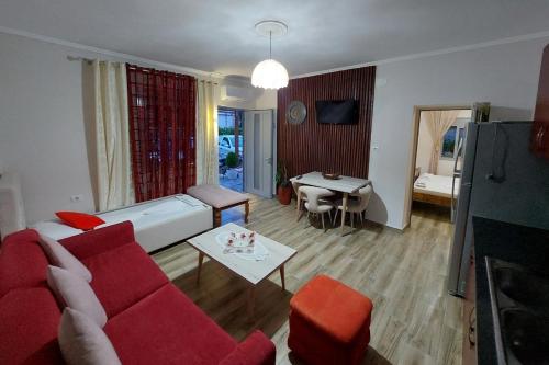 伏罗拉villa Heljos apartaments的客厅配有红色的沙发和桌子