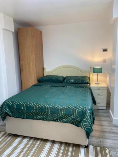 WellingOak Lodge的一间卧室配有一张带绿色棉被的床