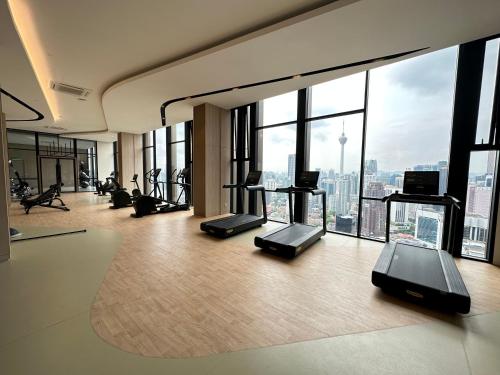吉隆坡Axon Residence By Perkasa Suites的带有氧器材的健身房,位于带窗户的大楼内
