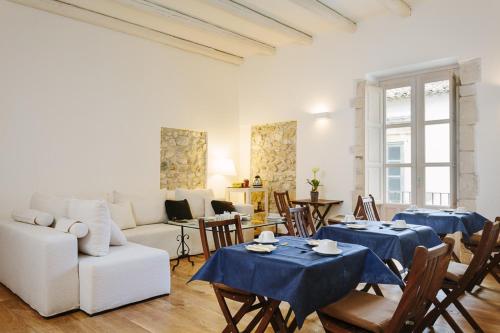 锡拉库扎B&B Palazzo Del Sale的客厅配有两张桌子和一张沙发