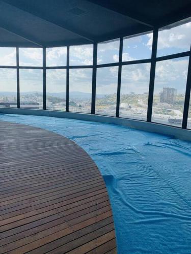 MirandaDepartamento elegante en Querétaro的一座大型游泳池,位于一座带窗户的建筑内