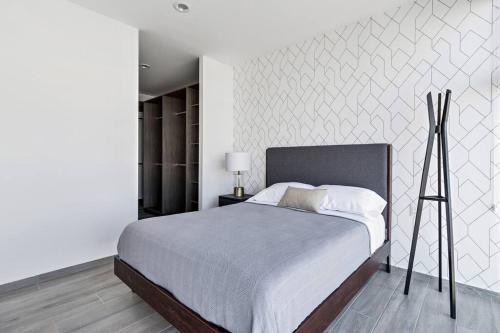 MirandaDepartamento elegante en Querétaro的一间卧室设有一张大床和白色的墙壁
