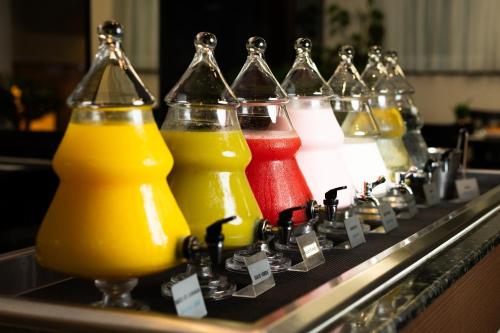 伊瓜苏圣拉斐尔舒适型酒店的玻璃瓶里一排不同颜色的果汁