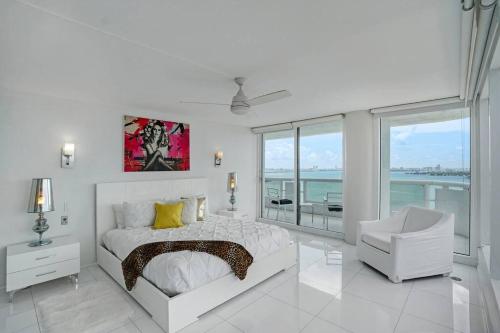 迈阿密Seas The Day! Complete Panoramic Water Views的白色卧室配有床和椅子