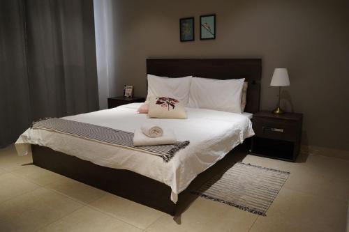 科威特Nakheel Residence Sabah Alsalem by House living的一间卧室配有一张大床和两条毛巾