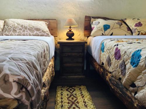 奥塔瓦洛Casa Victoria, habitaciones y zona de camping的一间卧室配有两张床和床头灯。