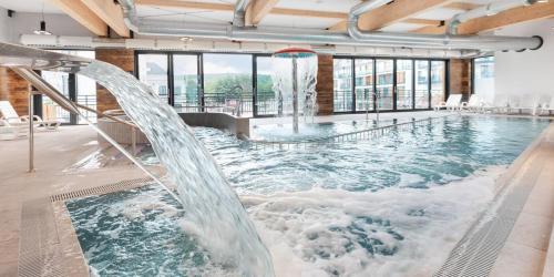 米兹多洛杰Bel Mare Resort ekskluzywny apartament dla wymagających klientów的大楼内一个带水滑梯的大型游泳池