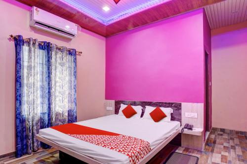 MotīhāriOYO Flagship 81389 Hotel Siddhi Vinayak的卧室设有粉红色的墙壁和一张床