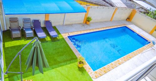 阿克拉Pool House Retreat in Accra的享有带椅子和遮阳伞的游泳池的顶部景致