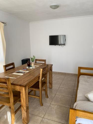 圣罗莎Complejo Pampa 2的一间带木桌和沙发的用餐室