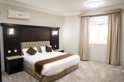 艾卜哈عنوانك للشقق المخدومة的一间设有大床和窗户的酒店客房