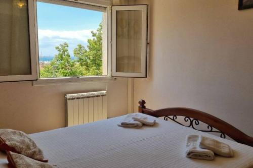 罗萨斯Piso en el centro con vistas al mar y balcón的一间卧室配有带毛巾的床和窗户。