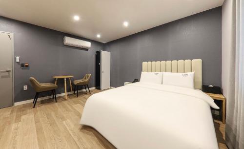 统营市Hotel Laon的卧室配有一张床和一张桌子及椅子
