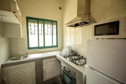 圣多美YUPOP APARTAMENTO的厨房配有水槽和白色冰箱
