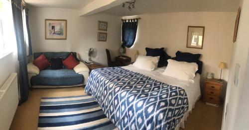 亨廷登Ye Olde Globe & Chequers的卧室配有蓝色和白色的床和椅子