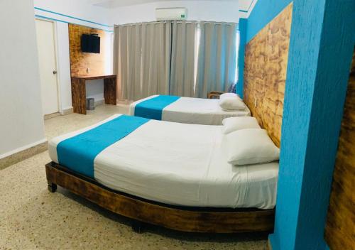 阿卡普尔科Hotel Lu Acapulco的蓝色和白色的客房内的两张床