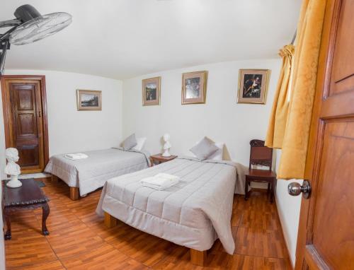 利马Casa Lima的一间卧室设有两张床,铺有木地板