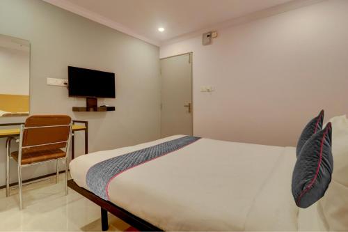 海得拉巴Townhouse Rcc Premier Sr Nagar的一间卧室配有一张床、一张书桌和一台电视