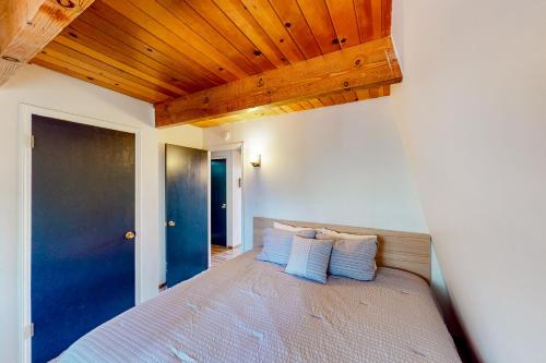 格罗夫兰Cozy Cabin的一间卧室配有一张带蓝色枕头的床。