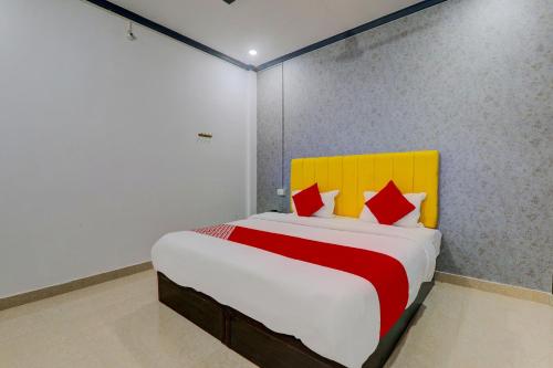 勒克瑙OYO Flagship Ideal Inn的一间卧室配有一张红色和黄色床头板的床