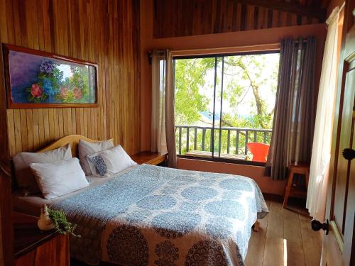 蒙泰韦尔德哥斯达黎加Casa de Montaña Tica Linda的一间卧室设有一张床和一个大窗户