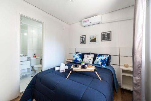 圣保罗Rover 25 Centro的一间卧室配有一张蓝色的床和一张桌子