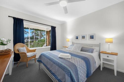 文森提亚AXL Orion Beach Home: Beach front的一间卧室配有一张床、一张书桌和一个窗户。
