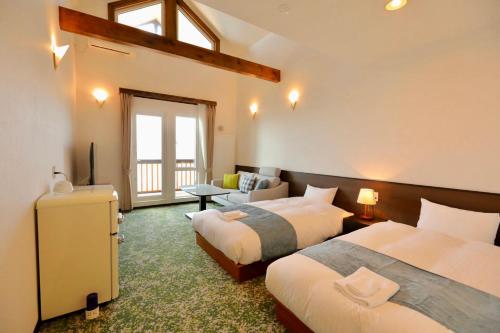 小樽小樽迎浜館的酒店客房设有两张床和窗户。