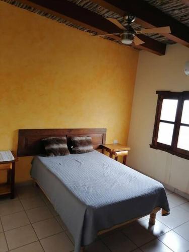 阿拉莫斯Departamentos TABAN El barranco的一间卧室设有床、两张桌子和一扇窗户