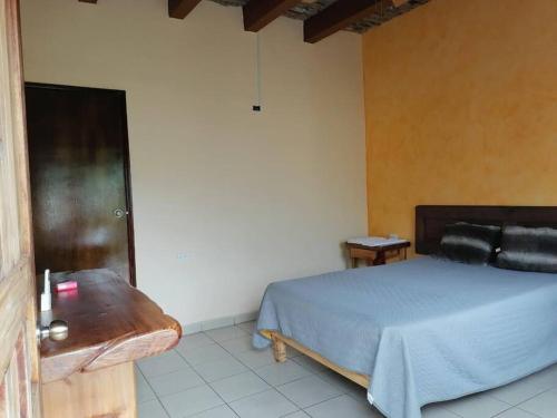 阿拉莫斯Departamentos TABAN El barranco的一间卧室配有一张床和一张木桌