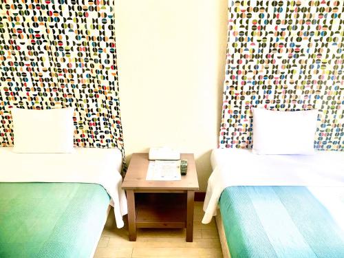 石垣岛石垣幸福假日酒店的两张床铺位于一个房间,中间有桌子