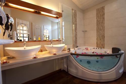 莱斯波特斯雷岛门酒店的浴室配有两个盥洗盆和浴缸。