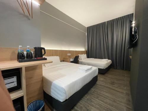 瓜拉丁加奴DJ Citi Plaza Hotel & Suites的酒店客房设有两张床和电视。
